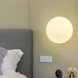 Wandlamp met matte glazen bol en gouden wandbevestiging